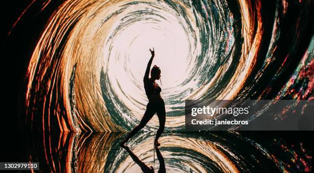 dancer silhouette performing ballet poses on projection background. surreal, digital tunnel with neon light - woman rap stock pictures, royalty-free photos & images