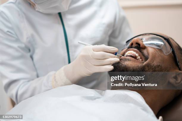 paciente durante consulta dental - odontología cosmética fotografías e imágenes de stock