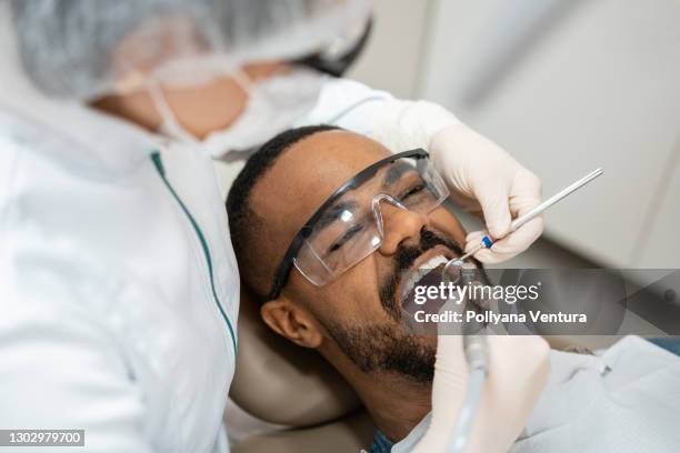 dentista che utilizza trapano dentale - dentist office foto e immagini stock