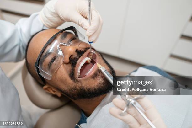 dentista aplicando anestesia al paciente - odontología cosmética fotografías e imágenes de stock