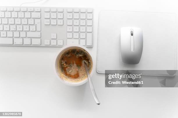 instant noodles cup with computer keyboard and mouse on desk at home office - mouse pad stock-fotos und bilder