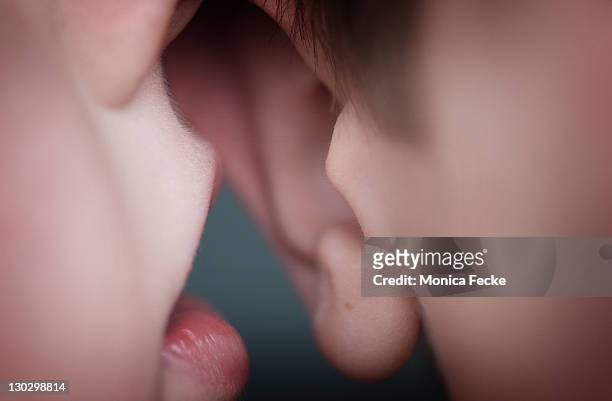 closeup of lips and ear sharing secret - mouth and ear stock-fotos und bilder