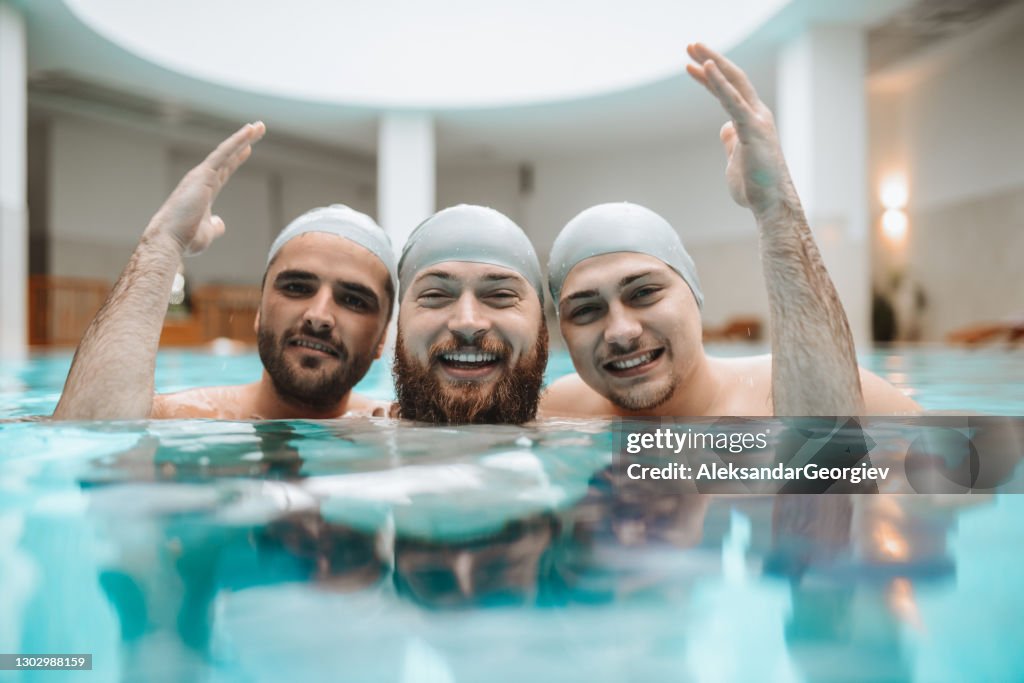 Smiling Handsome Male Friends Enjoying Swimming Pool