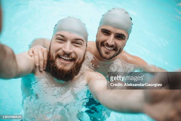 feliz pareja gay tomando selfie en la piscina - grupo de competencia fotografías e imágenes de stock
