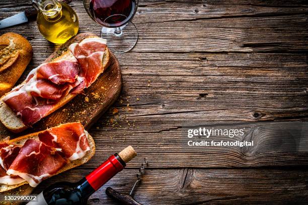 spanish food: iberico ham sandwich, spanish bocadillo de jamon iberico and rew wine. copy space - jamón serrano stock pictures, royalty-free photos & images