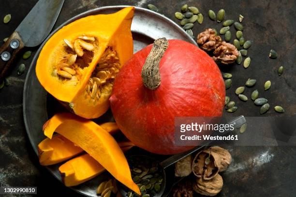 walnuts, pumpkin seeds and redkurisquashes on rustic baking sheet - squash seeds bildbanksfoton och bilder