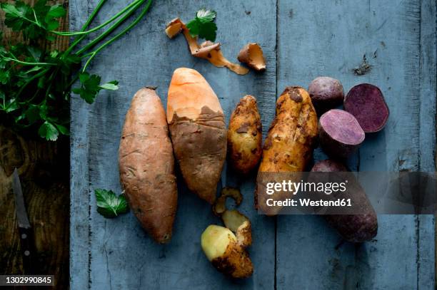 parsley and different varieties of potatoes lying on wooden surface - prepared potato stock pictures, royalty-free photos & images