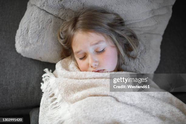 sick girl sleeping with blanket on sofa at home - lying on back girl on the sofa stock pictures, royalty-free photos & images