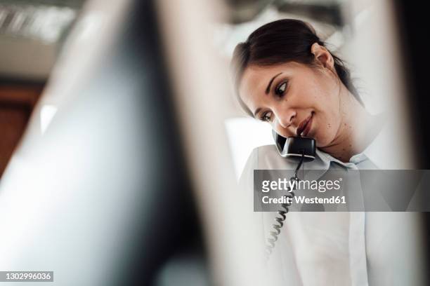 female entrepreneur talking on landline phone at office - festnetzanschluss stock-fotos und bilder