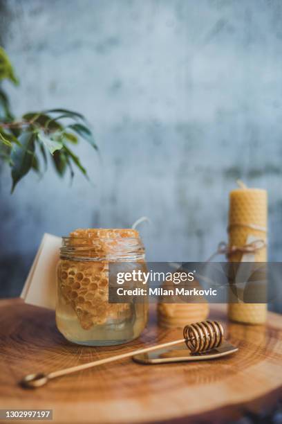 glas honig mit wabe. honig in einem glas auf einem hölzernen rustikalen tisch. - pot of gold stock-fotos und bilder