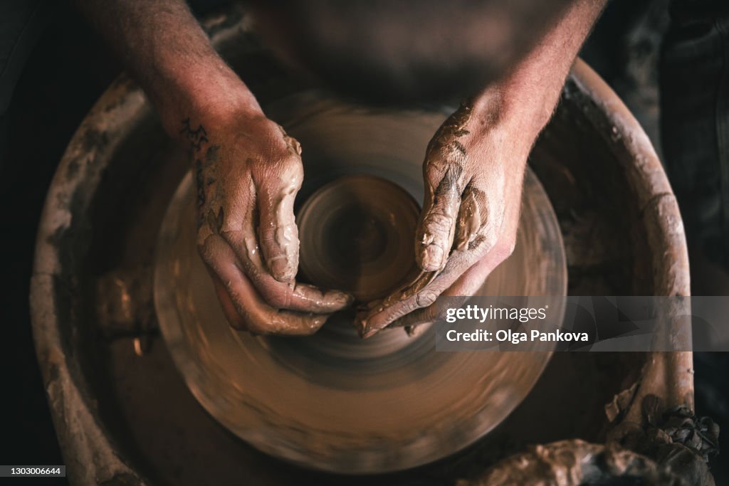 Hands of master in process of work in pottery / ceramic workshop. Small business concept.