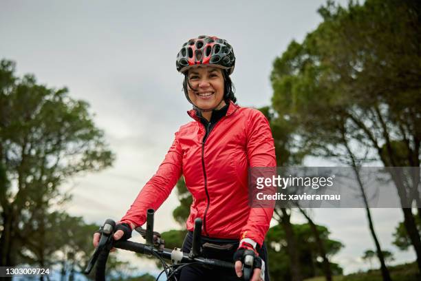portrait of cheerful early 50s hispanic female cyclist - cap de creus stock pictures, royalty-free photos & images