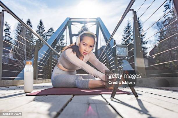 yoga instructor exercises at the bridge and filming whit gopro. - woman smiling facing down stock pictures, royalty-free photos & images