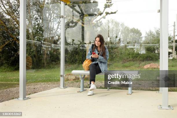 jovem estudante esperando ônibus - local girls - fotografias e filmes do acervo