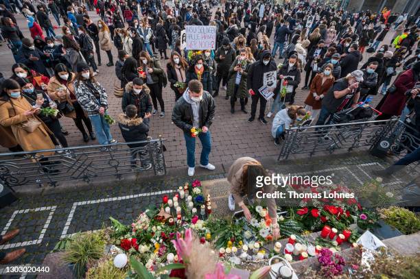 People lay candles and flowers at the Brothers Grimm Monument in front of the pictures and the names of the victims of the right-wing terrorist...