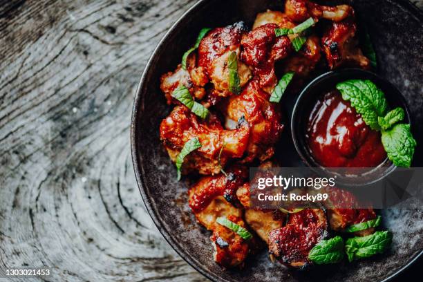 vegan buffalo wings made of cauliflower florets with bbq-sauce - cauliflower bowl stock pictures, royalty-free photos & images