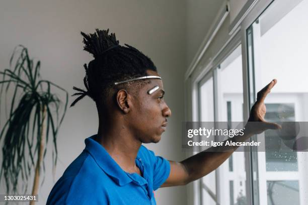 man wearing futuristic device on his head and browsing smart window (futuristic) - implant stock pictures, royalty-free photos & images