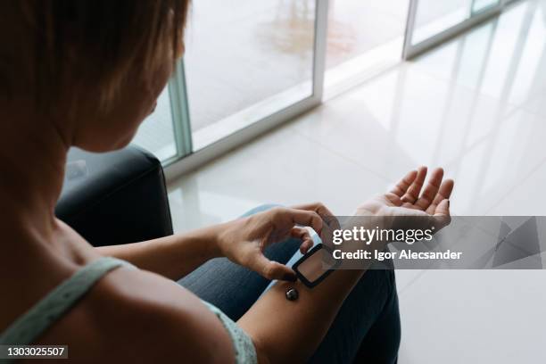 woman installing smart screen on her arm (futuristic) - computador utilizável como acessório imagens e fotografias de stock