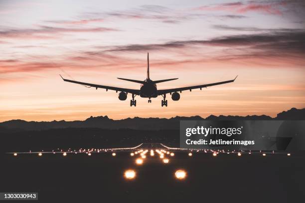 vliegtuigen die bij zonsopgang landen - land stockfoto's en -beelden