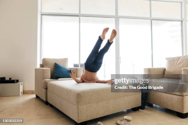 low section of playful girl falling on sofa at home - rear view hand window stock pictures, royalty-free photos & images