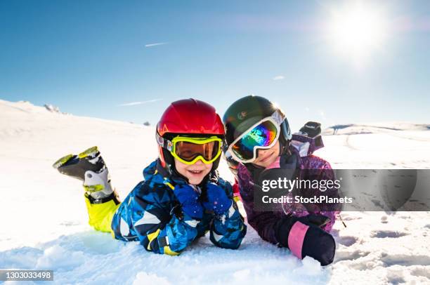 portrait of little skiers smiling at the camera - family winter sport stock pictures, royalty-free photos & images