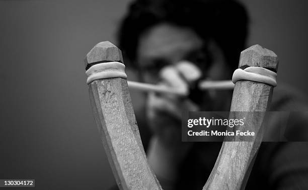 woman behind cocked slingshot - catapult stock pictures, royalty-free photos & images