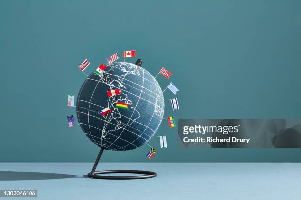 a world globe marked with several national flag pins - comunicazione globale foto e immagini stock