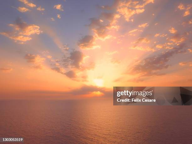 dramatic sky during sunrise over tranquil water. - zonsopgang stockfoto's en -beelden