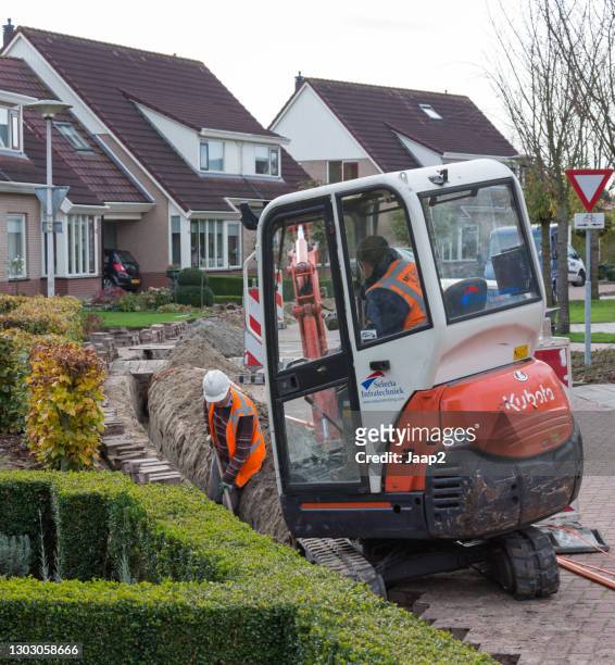 workers preparing dutch homes for using fiber optics (ftth) - trench town stock pictures, royalty-free photos & images