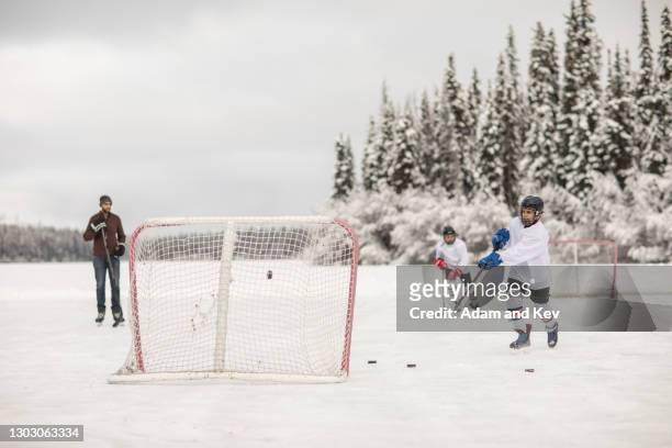 ice-hockey players practice on an outdoor ice rink - ice hockey stock pictures, royalty-free photos & images