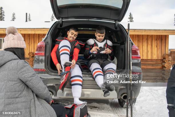 brothers dress in ice-hockey equipment - hockey mom stock pictures, royalty-free photos & images