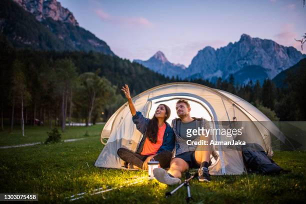 campistas eslovenos admirando la vista desde tent porche al atardecer - camping fotografías e imágenes de stock