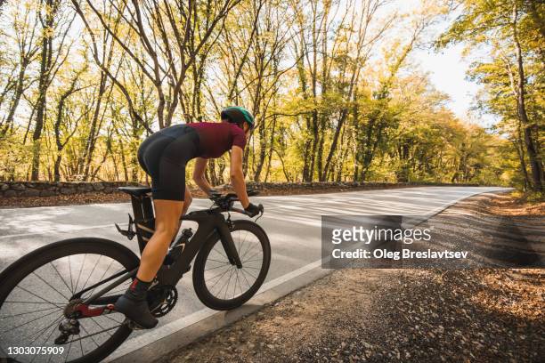 riding a bike, view from behind and way forward in perspective. unrecognizable person, room for copy space - go forward stock-fotos und bilder
