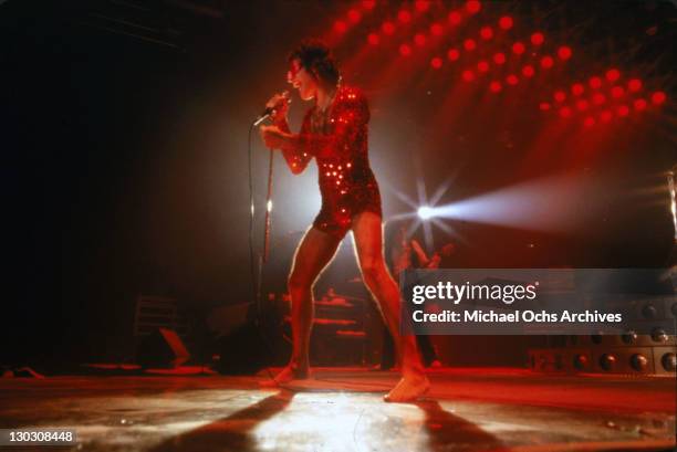 Singer Freddie Mercury of British rock band Queen in concert in a red sequined jumpsuit, 1978.