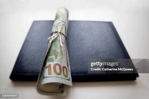 school diploma wrapped in $100 bills & traditional leather diploma binder - college tuition stock-fotos und bilder