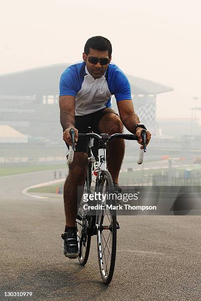 Team Lotus reserve driver Karun Chandhok of India cycles the track as preparations continue during previews to the Indian Formula One Grand Prix at...