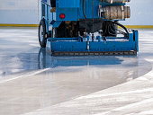 Ice resurfacer smoothing and polishing the surface of the ice rink