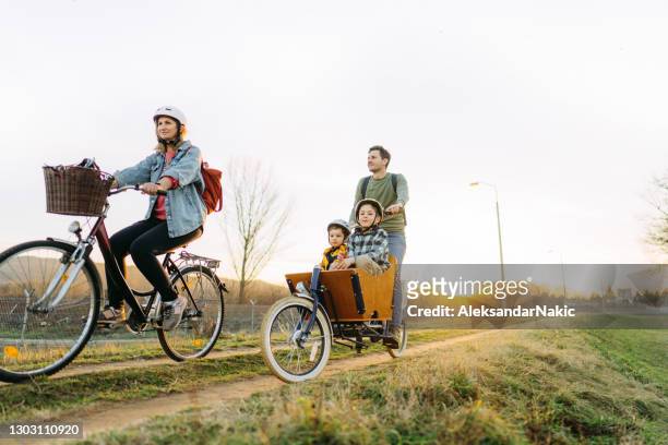 family on a bike ride - two kids with cycle imagens e fotografias de stock