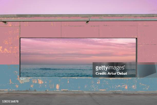 panoramic window in colorful concrete wall matching with the seascape sunset view. - contemporary arts center stock pictures, royalty-free photos & images