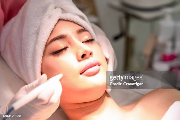 portrait of young woman with the beauty clinic backgrounds with receiving facial microdermabrasion treatment. - beauty treatment fotografías e imágenes de stock