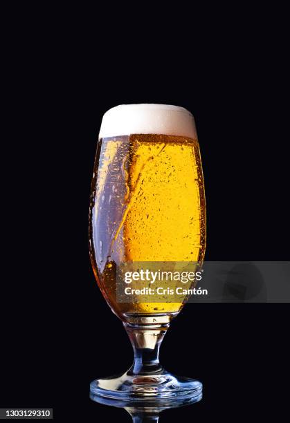glass of beer in black background - lager stock pictures, royalty-free photos & images