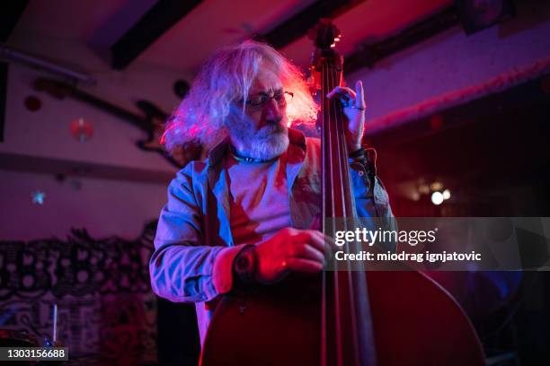 senior double bass player enjoying the feeling when he performing on stage - double bass stock pictures, royalty-free photos & images