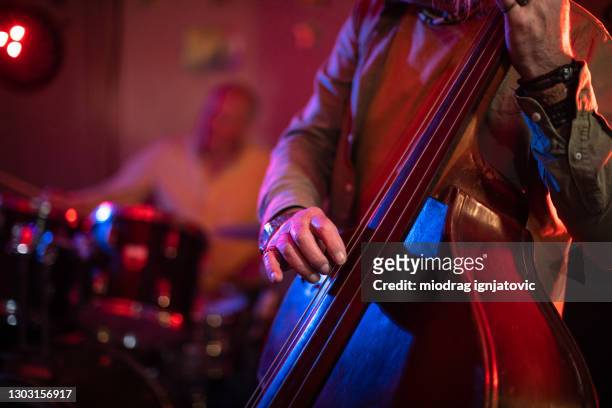 senior man playing double bass on stage with his band on gig - double bass stock pictures, royalty-free photos & images