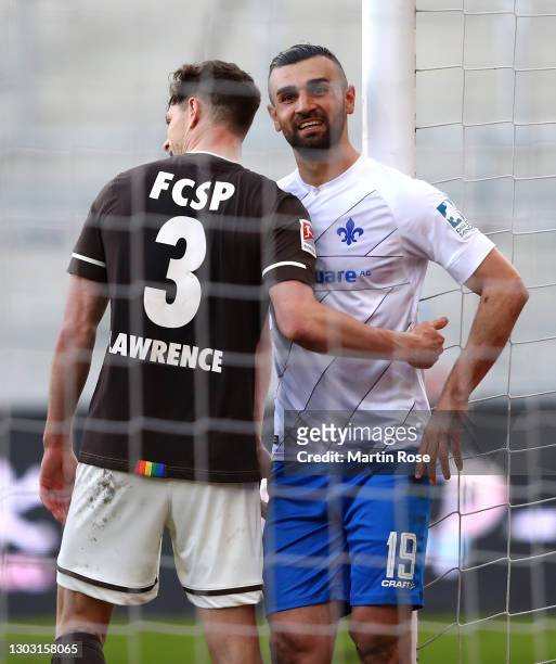 Serdar Dursun of SV Darmstadt 98 reacts as he is embraced by James Lawrence of FC St. Pauli following the Second Bundesliga match between FC St....