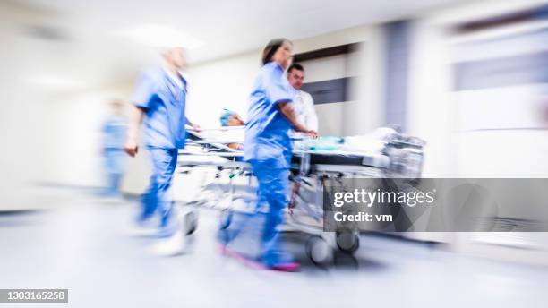 trabajadores médicos empujando camilla - hospital gurney fotografías e imágenes de stock