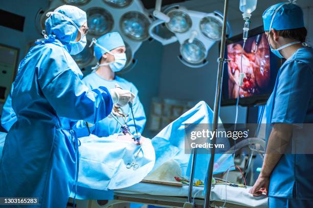 three surgeons doing laparoscopic surgery - laparoscopic surgery stock pictures, royalty-free photos & images