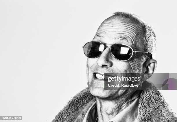 mature man in sunglasses and sheepskin jacket gives a wacky grin - face high contrast stock pictures, royalty-free photos & images