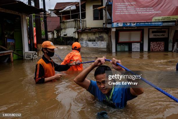 An Indonesian man walks through a flooded neighborhood on February 20, 2021 in Jakarta, Indonesia. Severe flooding in numerous areas of the...