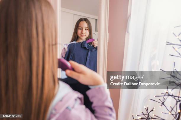 the girl chooses which dress to choose. - skinny teen ストックフォトと画像