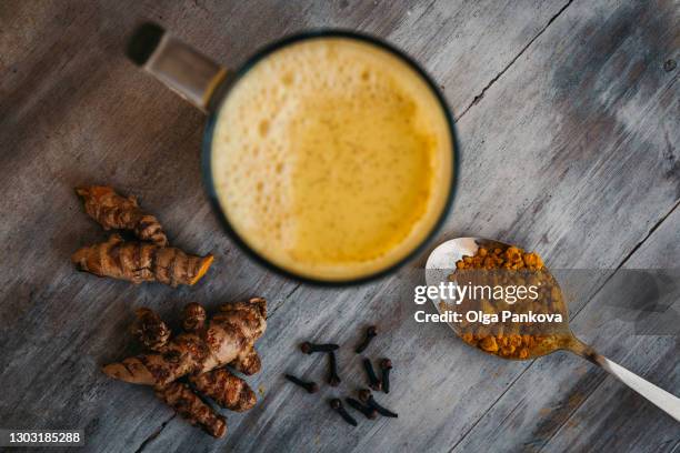 turmeric latte drink close-up top view. turmeric root and powder. superfood concept, healthy food lifehack. - masala tea foto e immagini stock